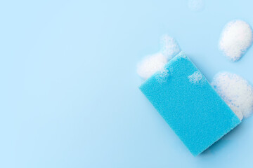 Multicolored sponges for cleaning on a blue background. Space for text.