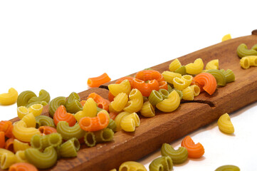 colored noodles on wooden board with a white background