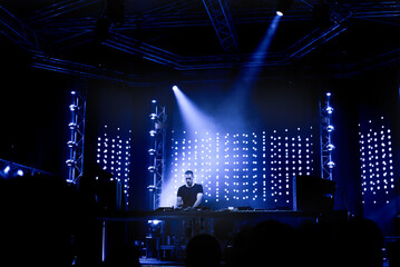 Dj playing techno music on the night concert in summer