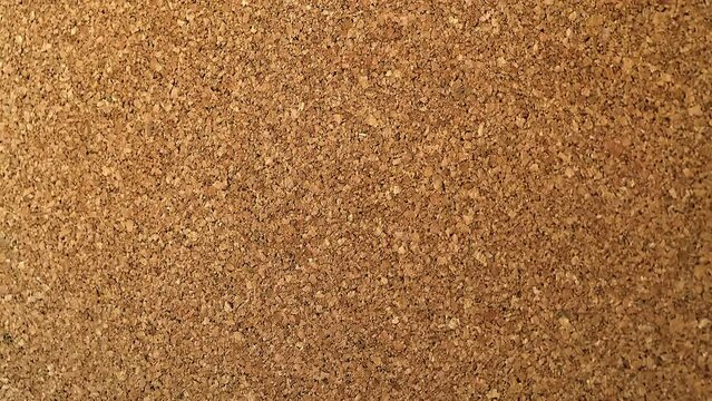 Throwing stickers into the cork board one piece at a time. The view is right on the note board. A wall with records in the office. Failed task. The paper flies into the board.