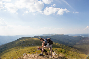 young woman with a dog in the mountains on a hike