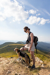 young woman with a dog in the mountains on a hike