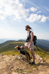 young woman with a dog in the mountains on a hike