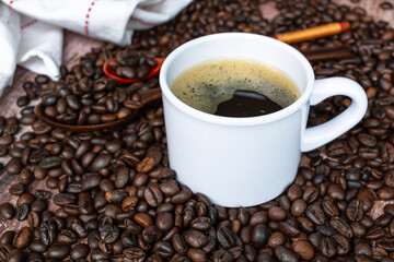 Cup of coffee on coffee beans and blurred background. Food and beverage concept.