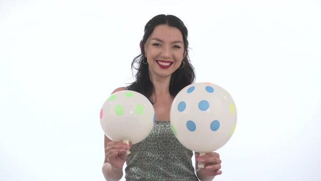 Deflated Party Balloons in the hands of a smiling pretty young woman on a white background. End of the Celebrating party. copy space