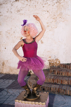 Funny female clown pretending to be ballerina during street performance