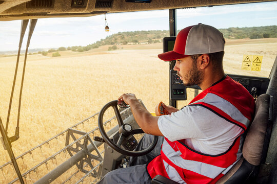 Man driving combine harvester