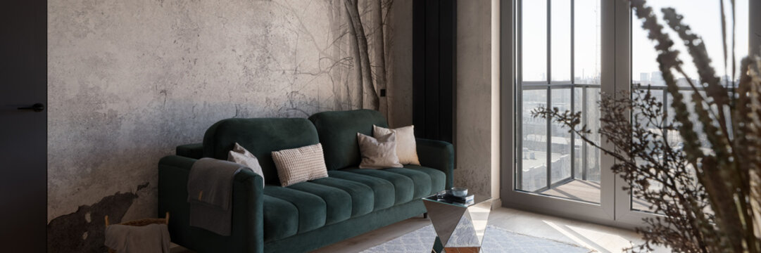 Green sofa in living room with big window, panorama
