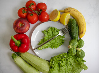 Plate of different vegetables and fruits on a light background