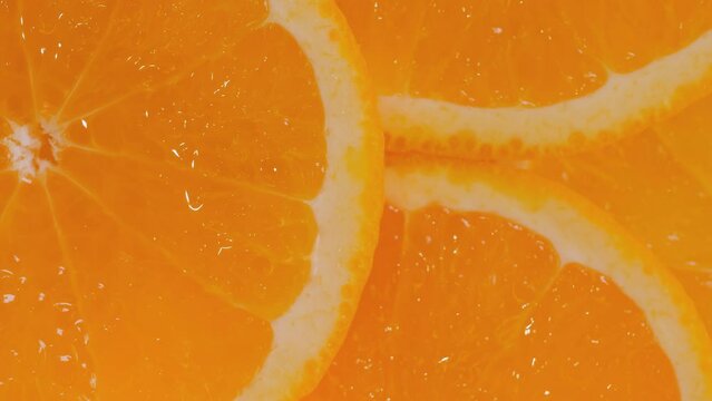 Macro: colorful fresh citrus fruit slices of orange on rotating surface - close up, top view. Tropical, natural, exotic, summer and healthy food concept