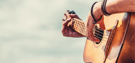 Man's hands playing acoustic guitar, close up. Acoustic guitars playing. Music concept