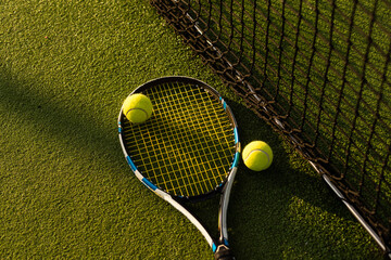 tennis balls and racket on the green grass background - obrazy, fototapety, plakaty