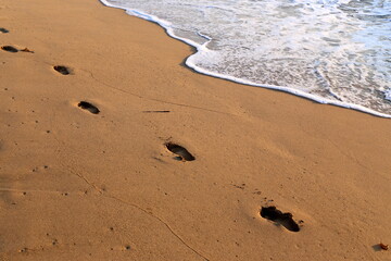 Footprints in the sand on the city beach.