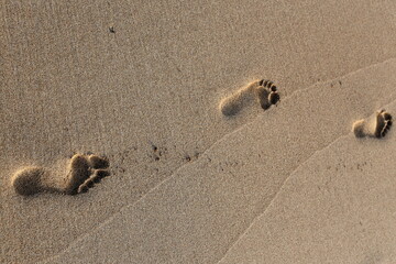 Footprints in the sand on the city beach.