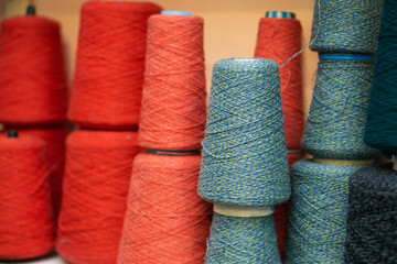 Multi-colored bobbins of yarn on a light back.