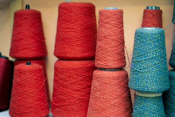 Multi-colored bobbins of yarn on a light back.