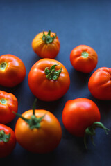 Fresh organic tomatoes, picked from the garden, on dark background. Selective focus.