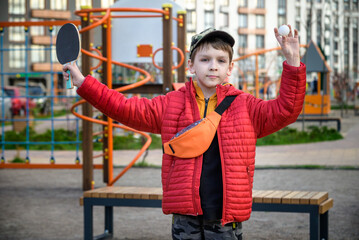 Caucasian boy exercise playing table tennis outdoors. Active leisure for children concept