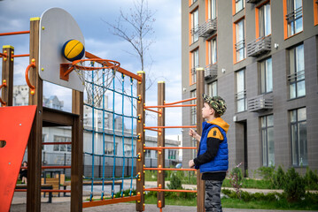Portrait of a boy with a basketball on a basketball court. The concept of a sports lifestyle, training, sport, leisure, vacation