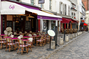 Cozy street with tables of cafe in quarter Montmartre in Paris, France. Architecture and landmarks...