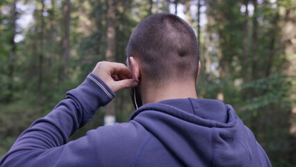 Athlete on road through forest. Back view. Athletic man on road through forest. Athletic man standing on trail through autumn forest