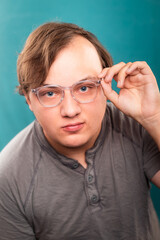 Man with glasses on a green-blue background