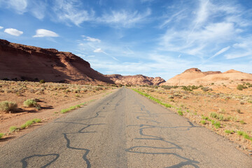 Scenic Road in the Dry Desert with Red Rocky Mountains in Background.
