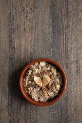 gekochter Haferbrei in Schale auf Tisch aus Holz