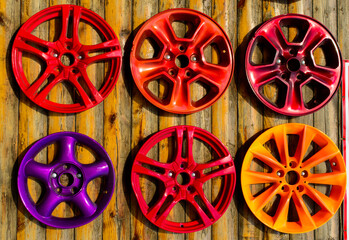 Set of a colorful wheel caps on the wooden wall. Ukraine, Odessa - car service. Background picture.