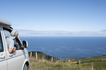 traveler at the van window after reaching the ocean © poliki