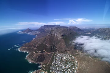 Foto auf Leinwand wide angle aerial view of coast line from Hout Bay to Cape Town with rocks twelve apostles, table mountain and lions head, blue sea, blue sky few white clouds © Andreas