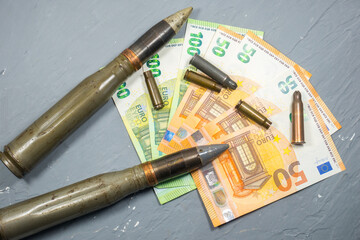 Euros money, bullets, shells, cartridges and projectiles on gray background. Lend-Lease concept.  Army concept. Sales of weapons and ammunition. Military industry, war, global arms trade.