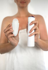 Fototapeta na wymiar woman holding roll-on deodorant and antiperspirant spray