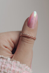Female hand with pastel pink nail and with beautiful stylish ring on finger. Close up photo. Nail polish.