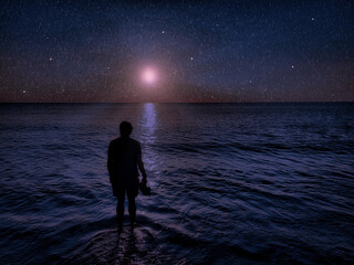 composition person in water ocean looking at night sky falling stars and moon