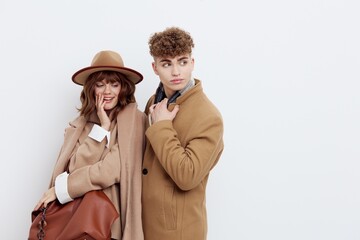a happy couple a man and a woman stand in stylish autumn clothes on a white background close to each other and smile happily