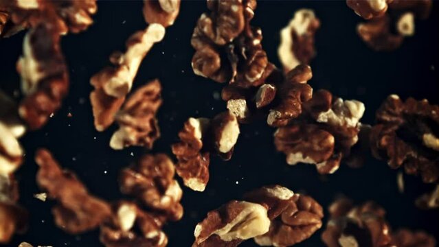 Peeled walnut rises up and falls down. Top view. On a black background. Filmed is slow motion 1000 fps.
