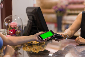 floristry hispanic female customer in flower business. payment with wireless technology. chroma key