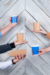 Male hands holding disposable cups with coffee Food delivery concept, coffee to go