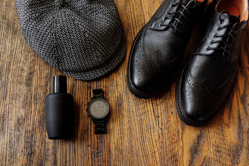 Men's outfits for man clothing set with black classic shoes, watch and vintage gray hat isolated on wooden background. Top view.