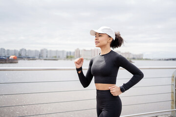 A woman runs, does fitness, uses a tracker on her arm, a smart watch for sports, trains in sportswear