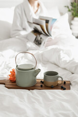 Wooden breakfast tray against woman on bed