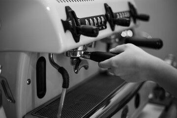 Barista holds a holder and makes coffee with a double-boiler coffee machine