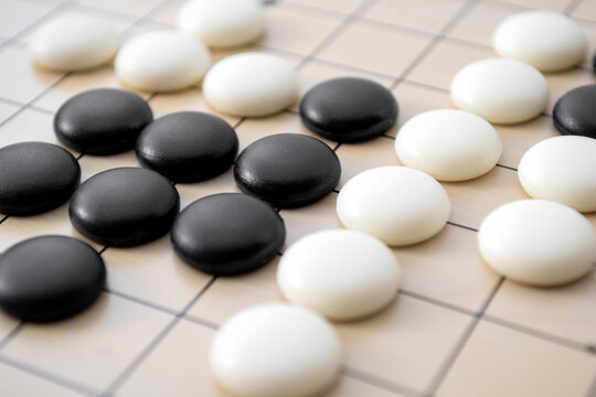 Full frame close up of go board with black and white stone pieces concept for intelligent strategy, difficulty games and competitive intelligence contest