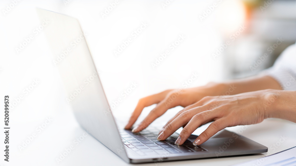 Wall mural Crop shot of woman hand works on laptop Bookkeeper or financial inspector hands with copy space making the report and calculating. Home finances, investment, economy, or insurance concept