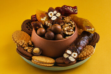 Churchkhela - Georgian national delicacy and nuts with cookies around on an orange background. Close-up
