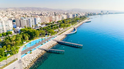 Foto op Canvas Luchtfoto van Molos Promenade park aan de kust van het stadscentrum van Limassol, Cyprus. Vogelperspectief van de steiger, wandelpad aan het strand, palmbomen, Middellandse Zee, pieren, stedelijke skyline en haven van bovenaf © f8grapher