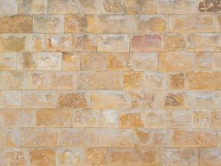 Travertine masonry texture. Facade cladding. Wall with orange rough masonry. Full screen photo. Not...