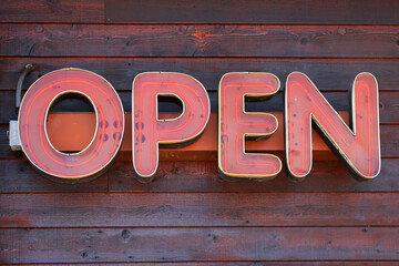 Wide neon open text on the exterior wall of the store.