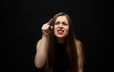 Negative human emotions and feelings. Grumpy angry young woman posing, frowning eyebrows, her look and grimace expressing anger, annoyance.